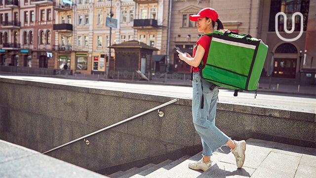 A delivery woman checking her online delivery app for restaurants